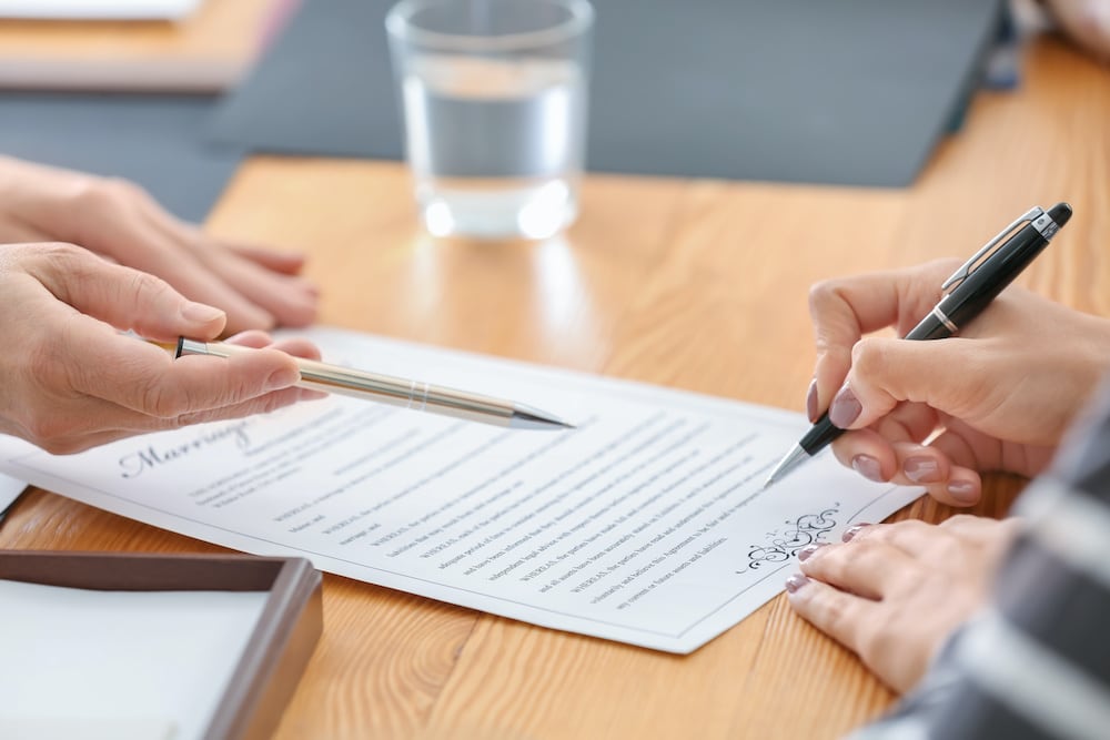 two people signing a document