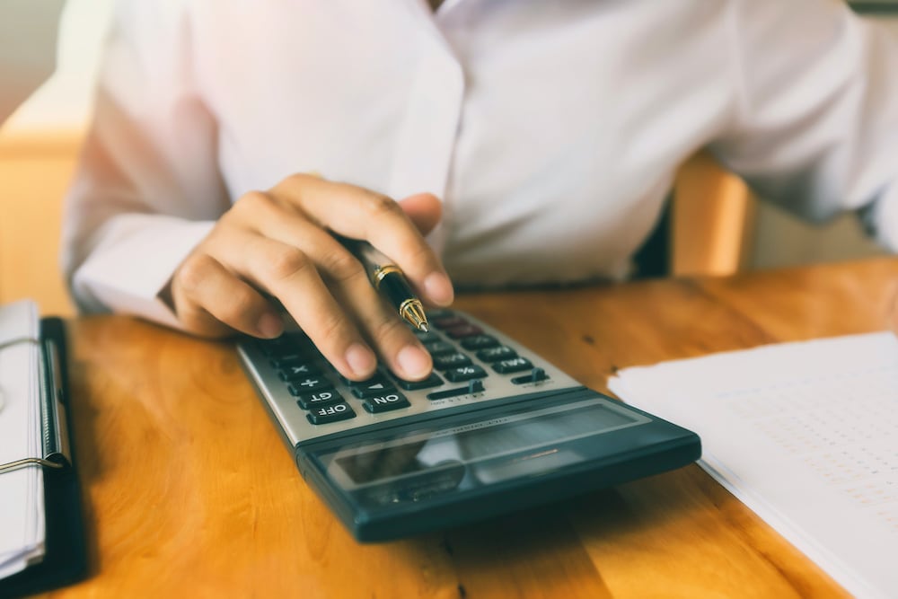 person using a calculator at a table