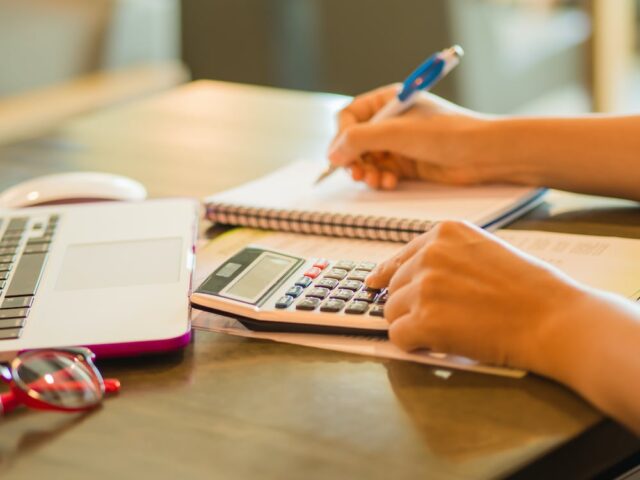 person using calculator at desk